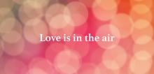 Love is in the air headline with glare circle pink background.